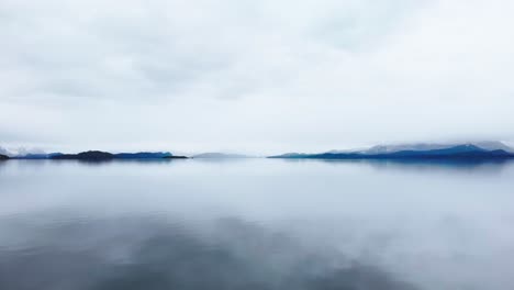 Una-Impresionante-Perspectiva-Aérea-De-Un-Sereno-Lago-Patagónico,-Con-Sus-Aguas-Cristalinas-Rodeadas-De-Montañas-Nevadas