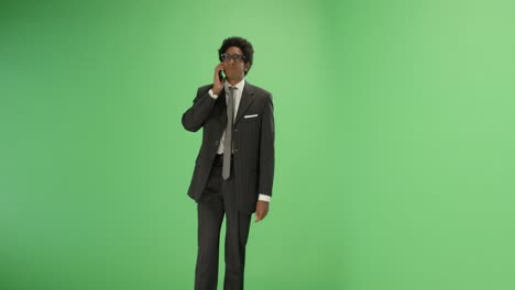 man in suit talking on phone with green screen
