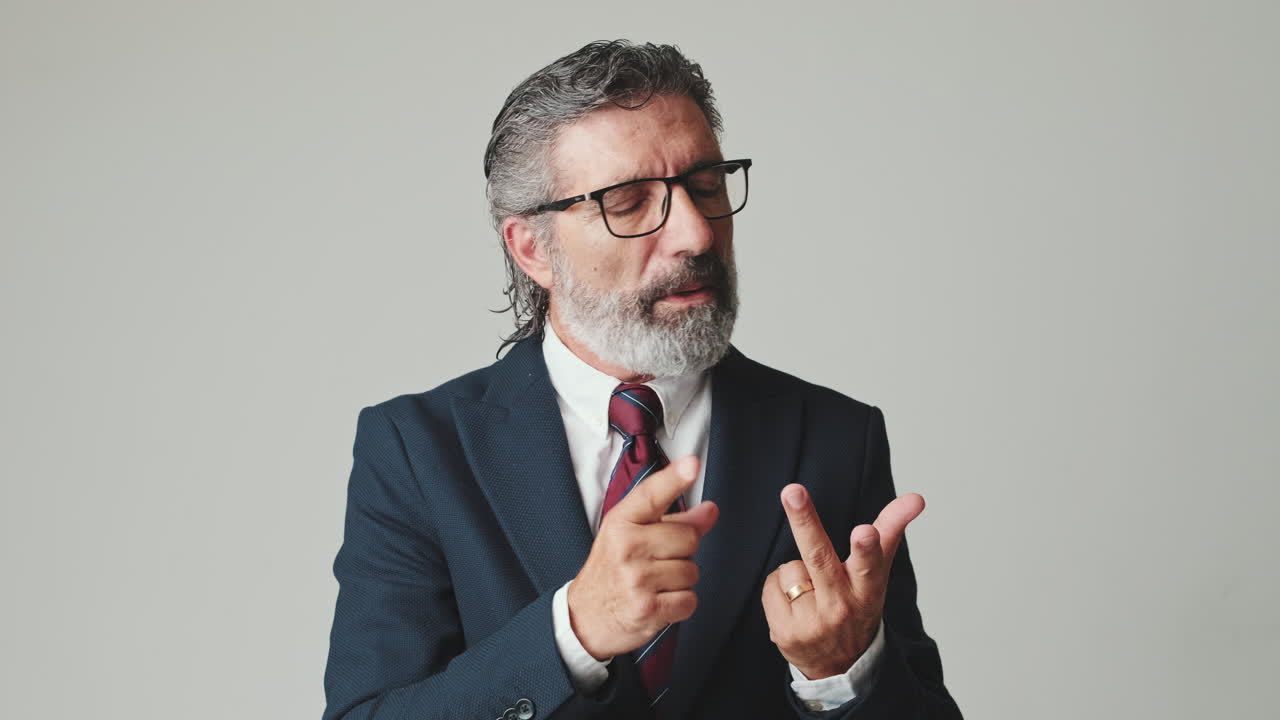 Mature Businessman Counting on Fingers and Explaining