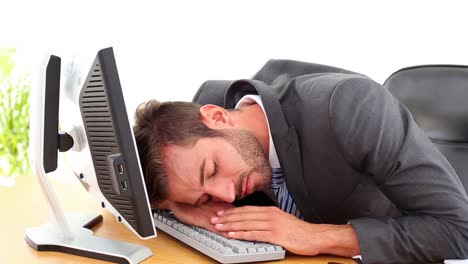 Exhausted-businessman-sleeping-at-his-desk