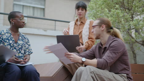 diverse colleagues brainstorming at outdoor coworking space