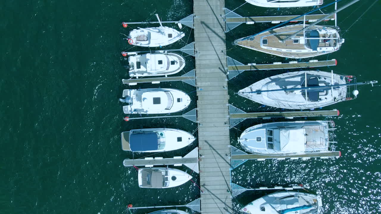 Top down aerial view on yachts stay in marina, expensive yacht and place on travel, beautiful green water in sea