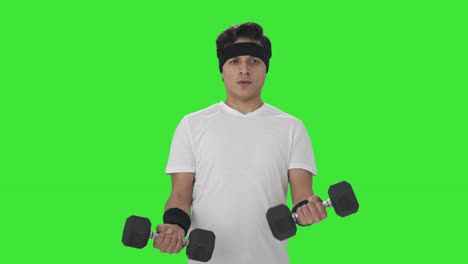 serious indian man lifting heavy dumbbells green screen