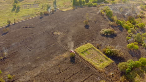 burnt field in summer. fire truck working on the field. brown field with smoke after the fire. fire disaster in nature. aerial view.