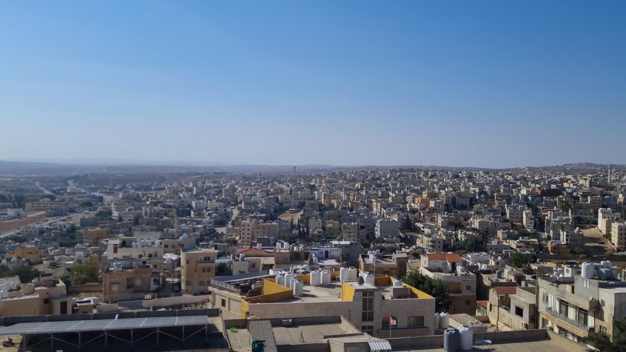 Ampia veduta del paesaggio urbano di Madaba, in Giordania, in una giornata di sole, che mostra edifici bassi che si estendono verso l'orizzonte in una delle città abitate ininterrottamente più antiche del mondo