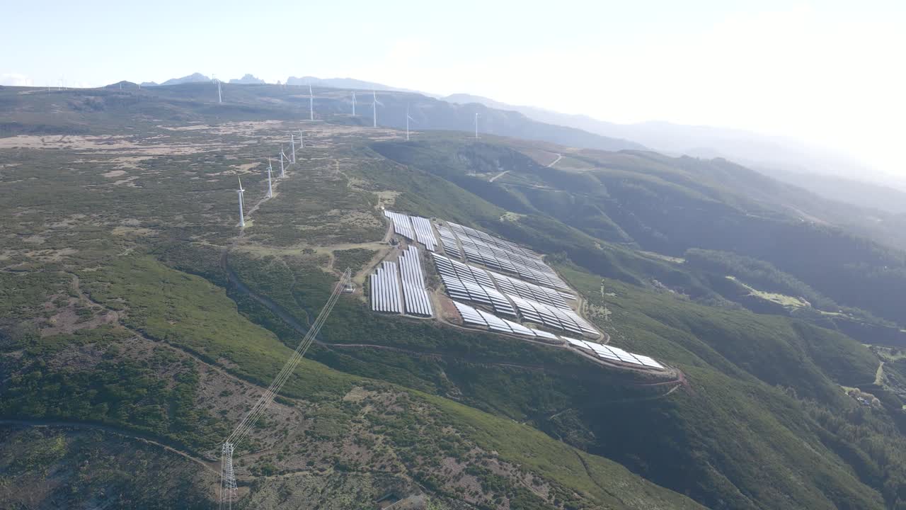 vista aérea de una granja fotovoltaica y una granja eólica en la cima de una montaña en la isla de paul da serra madeira