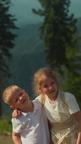 mother takes photos of positive children on smartphone against hilly mountains of wild nature in tourist area. relaxing with family and spending time together slow motion