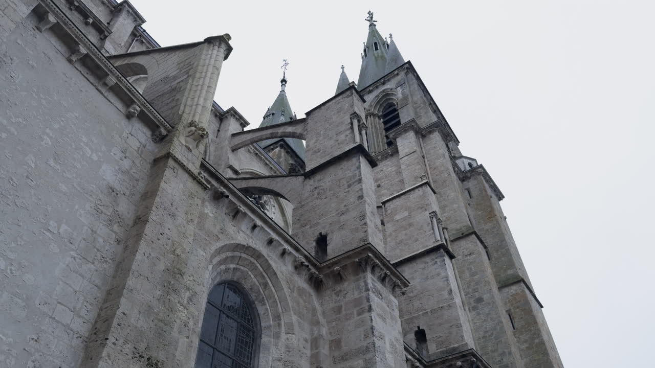 una iglesia de estilo gótico con torres altas y contrafuertes de piedra en un día nublado