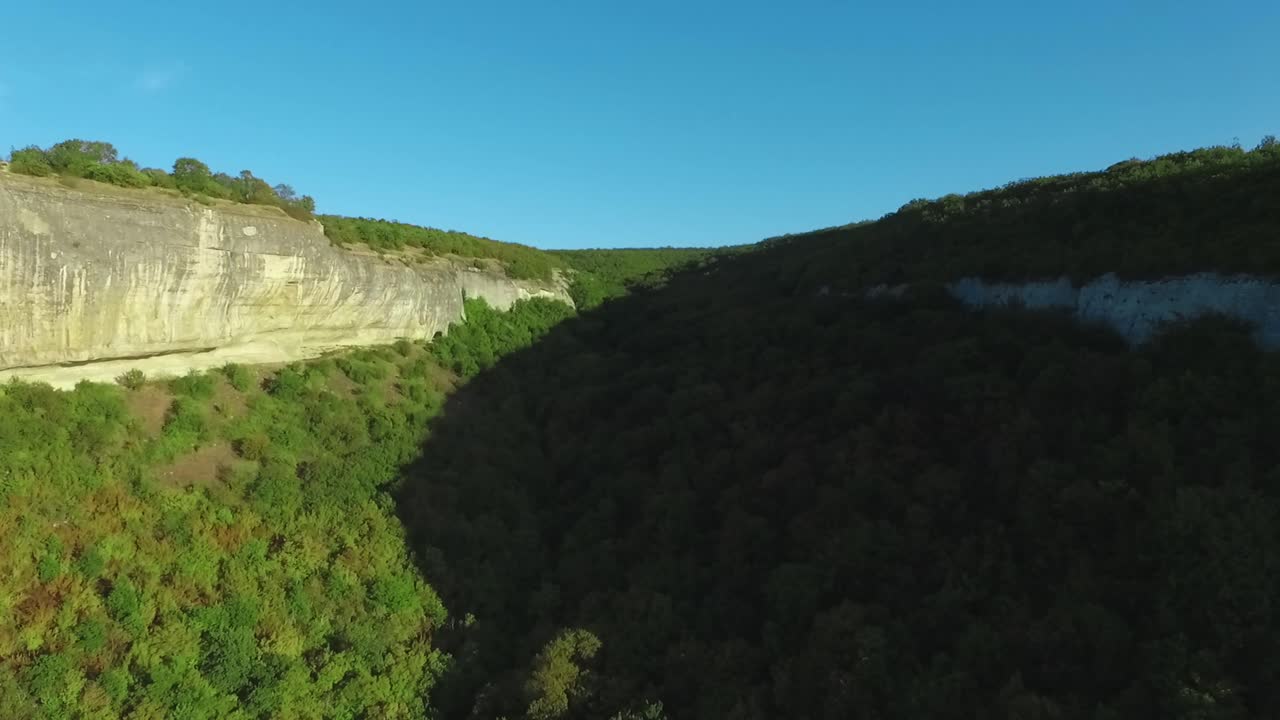 vista aérea de un valle de montaña con acantilados y bosque