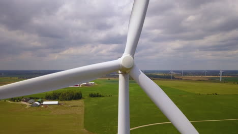 close-up aerial of the rotating blades of a wind turbine