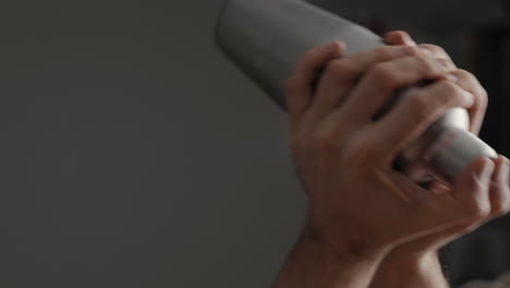 young male shaking cocktail in a mixer in the kitchen at home. slow motion close up hands