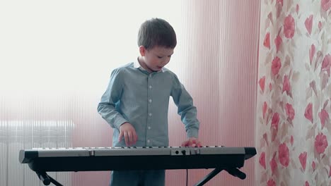 little boy playing on musical synthesizer