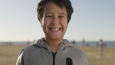 portrait of young hispanic boy smiling cheerful looking at camera enjoying summer day at seaside park