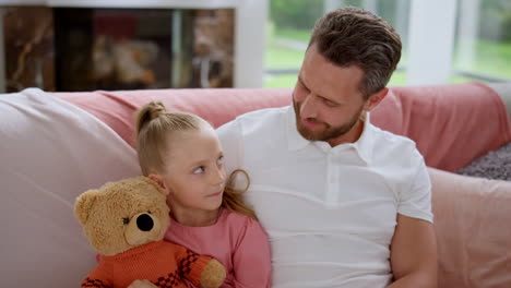 daughter having conversation with father in room. parent and kid talking at home