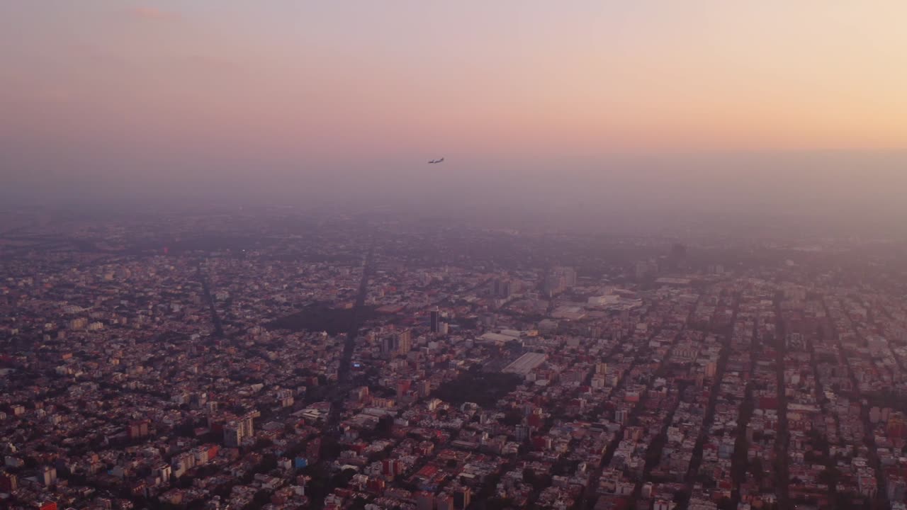 멕시코 시의 황금시간대에 상륙하는 상업용 비행기의 아름다운 공중 영상, 저녁 빛에 빛나는 스모그