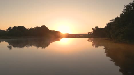 amanecer sobre un lago tranquilo y un bosque