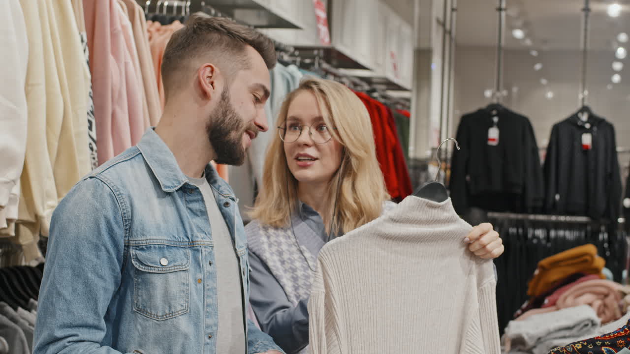Coppia alla moda che fa shopping in un negozio di abbigliamento