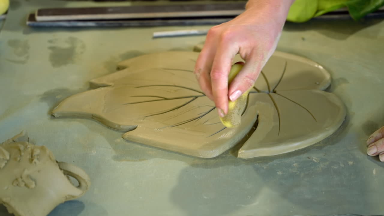 Woman modelling clay in a leaf shape