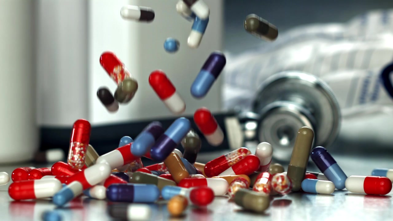 Pillole e capsule mediche colorate che cadono su una superficie