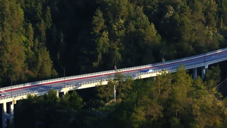 aerial view following a taxi on bridge, between mountains in china, golden hour
