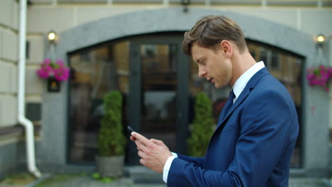successful business man using mobile phone outdoors. surprised businessman