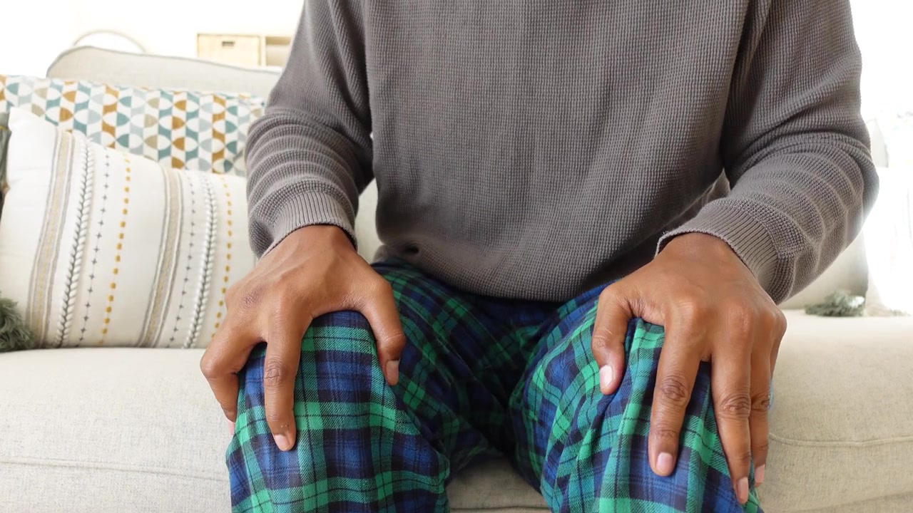 Person Sitting on Couch Wearing Plaid Pajama Pants