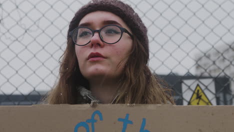 vista de cerca de una joven activista sosteniendo una pancarta de cartón y protestando para salvar la tierra durante una protesta contra el cambio climático