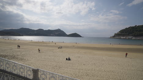 sandy beach near beautiful bay with cityscape view of san sebastian, pan right view