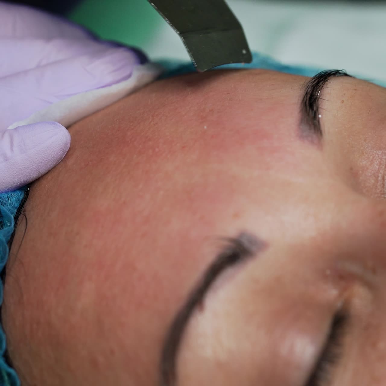 Beautician performs ultrasonic face skin cleansing using special device. Skincare concept. Extreme close up