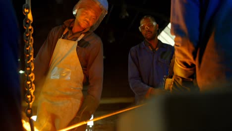 group of workers pouring molten metal in mold at workshop 4k