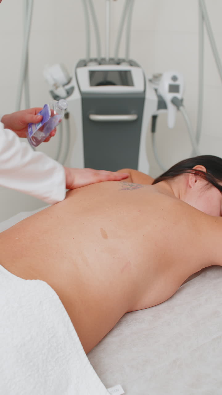 Beautician applying pouring oil and making woman relaxing revitalizing spa back treatment massage