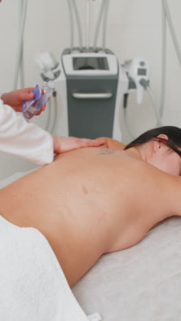 beautician applying pouring oil and making woman relaxing revitalizing spa back treatment massage