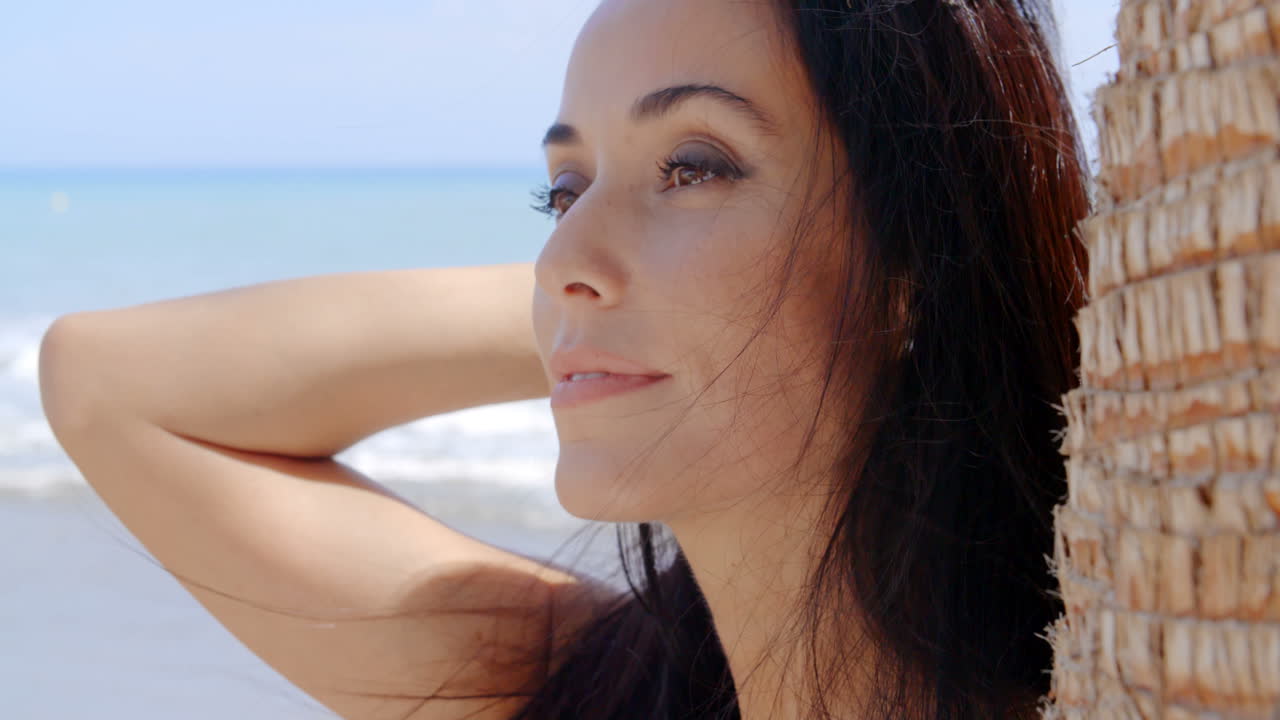 Splendida donna in spiaggia che guarda in lontananza