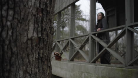 Establishing-shot-contemplative-girl-standing-on-bridge-in-the-park