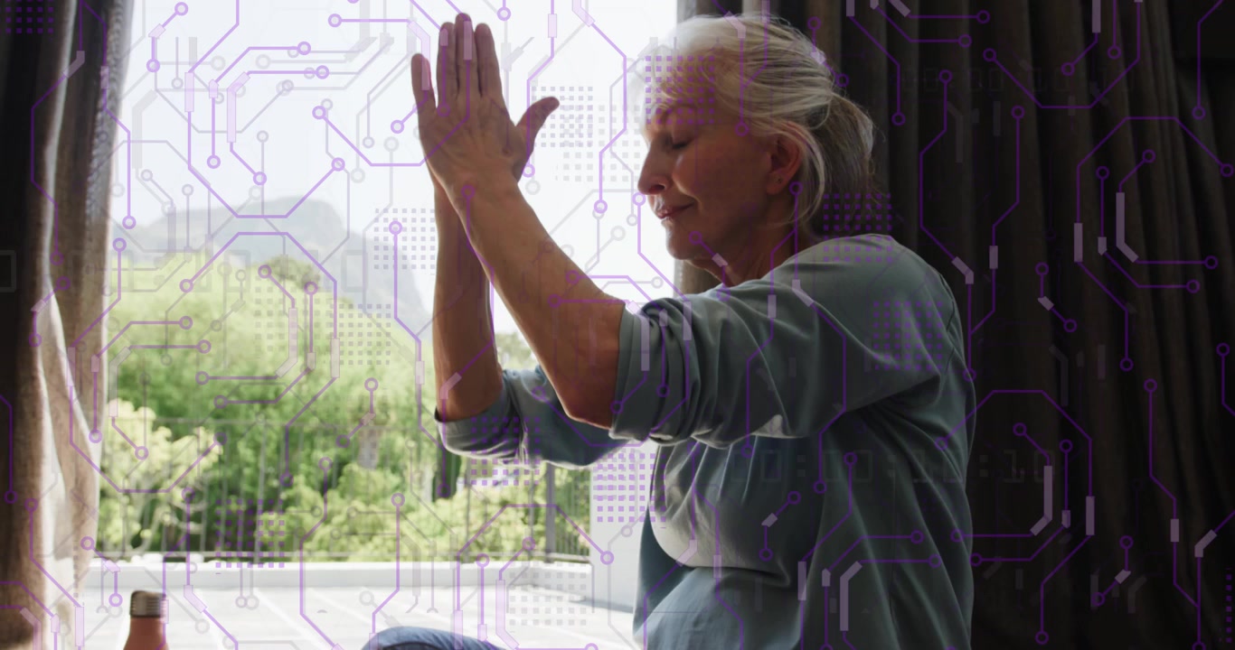Senior woman meditating by sunlit window for health breathing deeply, stretching arms upward