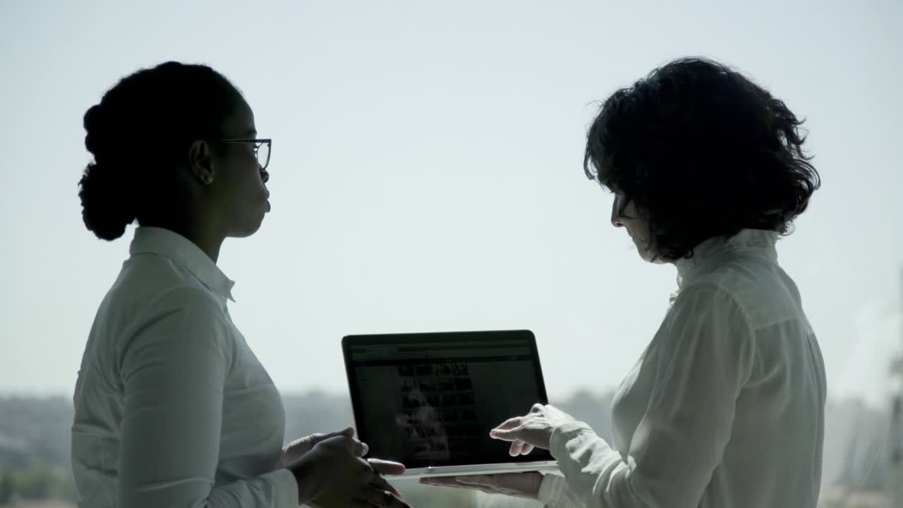 Serious businesswomen using laptop