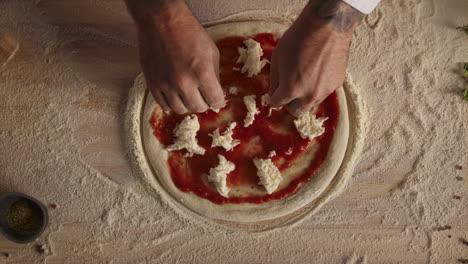 man cook making pizza pepperoni on flour board kitchen table at restaurant.