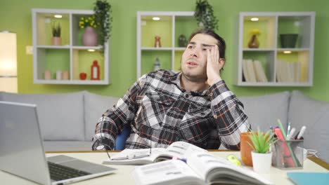 stressed young man works in his home office and his business is not going well.