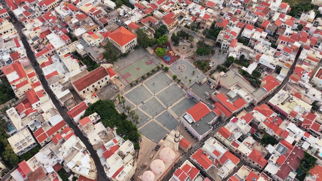 Vista aerea con drone del centro storico con tetti rossi e del minareto della Moschea di Neratze sopra le fitte strade storiche, Rethymno, Grecia