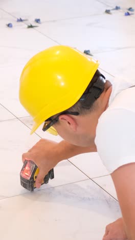 construction repair of laying ceramic tiles on a concrete floor the worker makes repairs in the