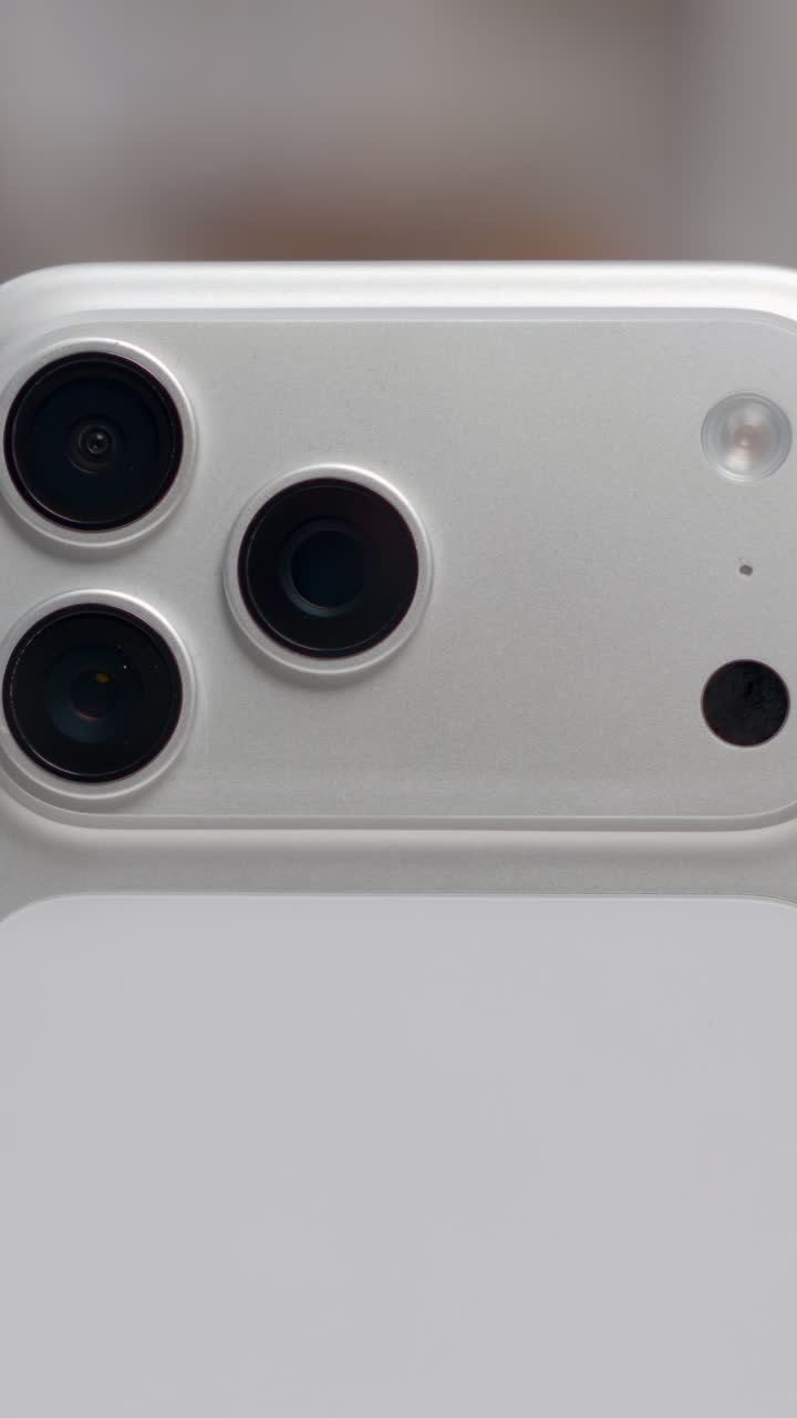 Primo piano di un nuovo smartphone bianco con un sistema a tripla fotocamera e sensori avanzati sul retro. Azione.