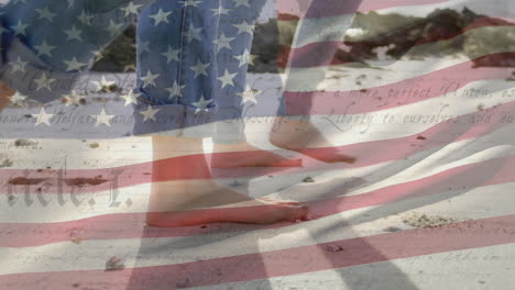 people walking on beach with us flag waving and constitution foreground