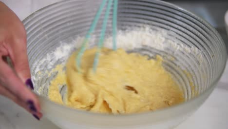 Woman-preparing-dough-mixing-ingredients-using-whisk-in-the-kitchen.-Homemade-food.-Slow-Motion-shot