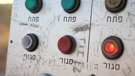 press push button on control panel with Hebrew text beneath, close up