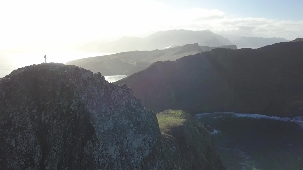Splendida ripresa grandangolare con drone della drammatica penisola di Ponta de São Lourenço a Madeira, Portogallo. Caratterizzata da imponenti scogliere vulcaniche in silhouette e un accecante riflesso del sole sull'oceano.