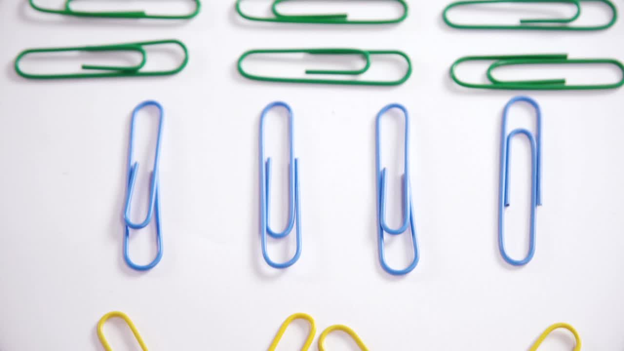 clips de papel coloridos dispuestos sobre un fondo blanco 4k