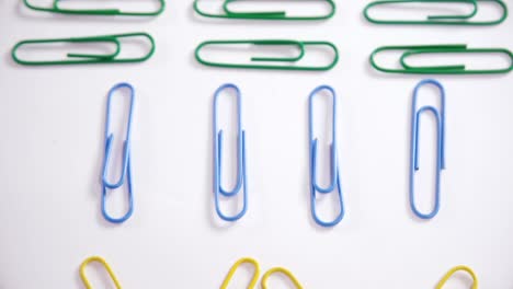 colorful paper clips arranged on white background 4k