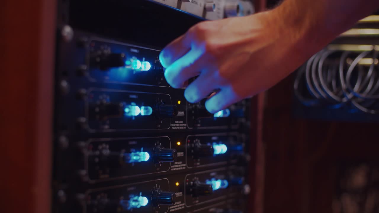 Hand of a man changing the gain of a Petrungaro preamplifier - Professional recording studio - 4K at 60fps (slowmotion) - Professional audio vives