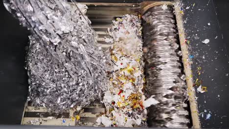 overhead shot of waste plastic being shredded at a waste recycling factory