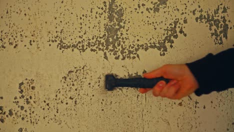 hand removing old paint from an old wall - close up